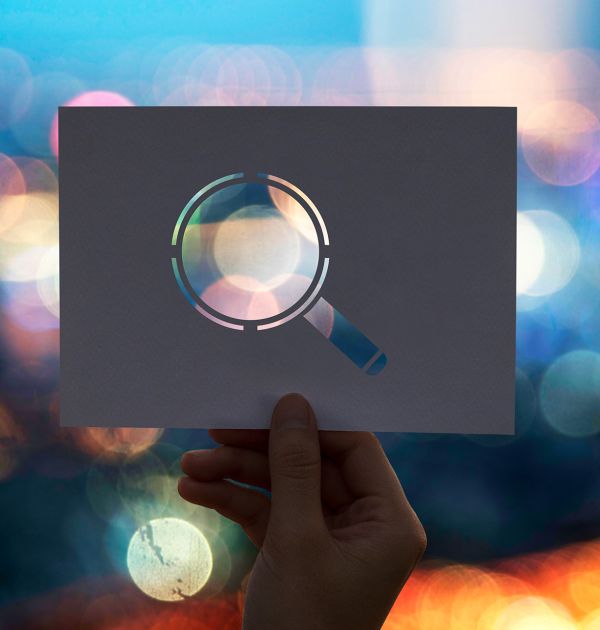 photo symbolisant la R&D avec une loupe et un arrière plan coloré et flou